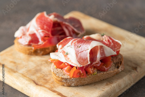 Fényképezés Crusty toast with fresh tomatoes and cured ham