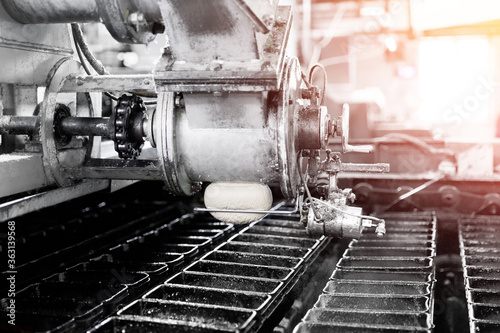 Filling metal molds for baking bread. Industrial bakery automated line