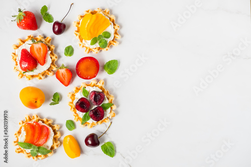 Top view of traditional Belgian waffles with soft cheese  fruits and berries with copy space. flat lay.