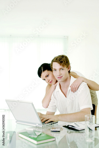 Woman watching her boyfriend using laptop