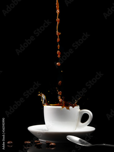 Pouring coffee into a white cup with splashes