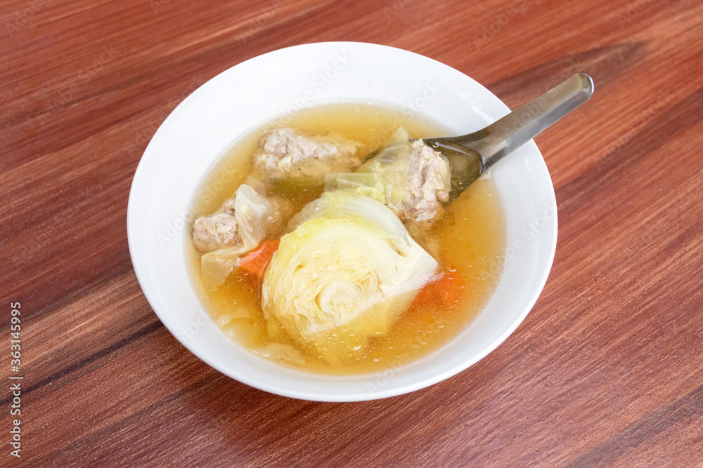 Cabbage clear soup with minced pork (Thai clear soup with vegetable) on dark brown wooden table. Cabbage clear soup with minced pork (Thai clear soup with vegetable) on dark brown wooden table.