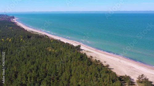 Aerial view flying towards Latvian Baltic sea seaside beach coast. Wind turbine near Liepaja photo