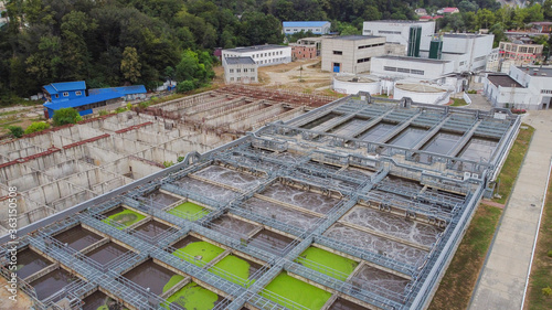Aerial view of treatment facilities in close urban development. Engineering infrastructure in the mountains.