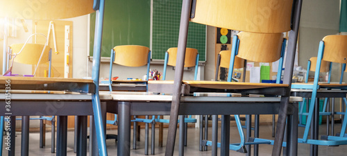 CORONAVIRUS - School closed - Empty classroom with high chairs and empty blackboard
