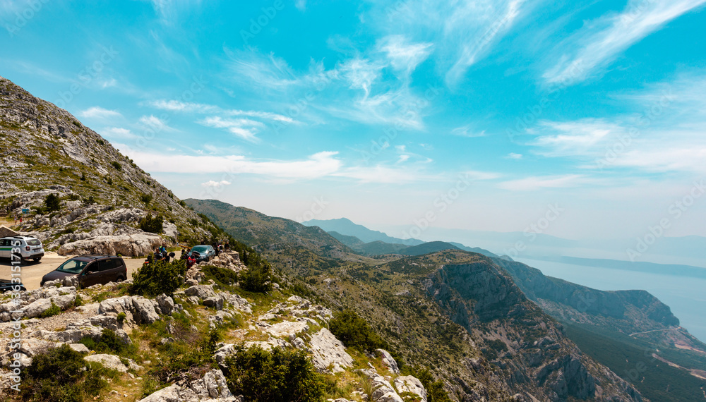 Area behind the Biokovo Skywalk in Croatia. Small parking zone where people struggle to find a parking spot. Seen with endless mountains going into the distance in the background