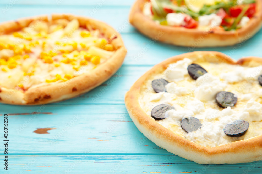 Variety of pizzas on blue wooden background Variety of pizzas on blue wooden background