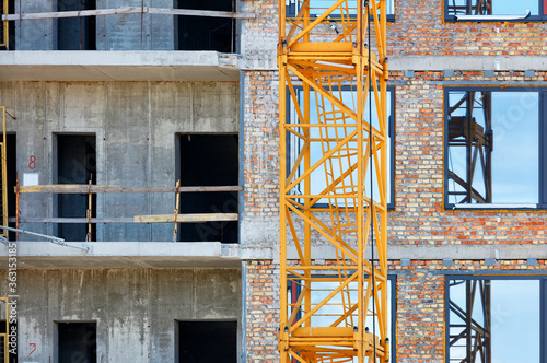 Element of the crane on the background of the facade and near the reconstructed residential building.