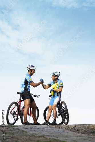 Male cyclists shaking hands