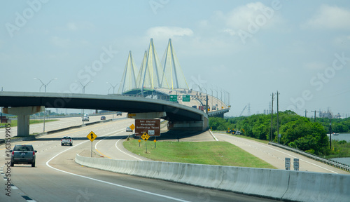 On a highway with a major junction and large cable suspension bridge in the distance photo