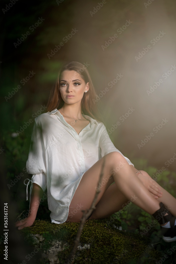 Young girl posing in a white shirt on forest background Young girl posing in a white shirt on forest background