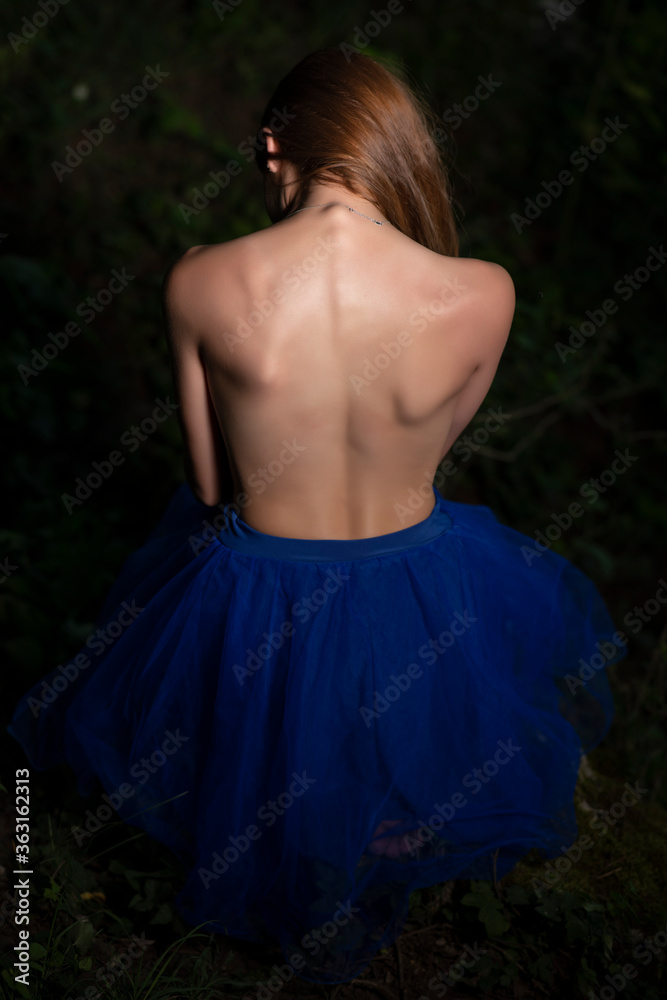 Young girl posing in a blue dress on forest background Young girl posing in a blue dress on forest background