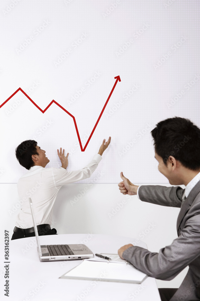Line graph going up, businessman giving thumbs up