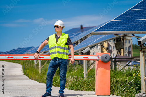 Engineer is looking out at new energy base of solar system pannels.