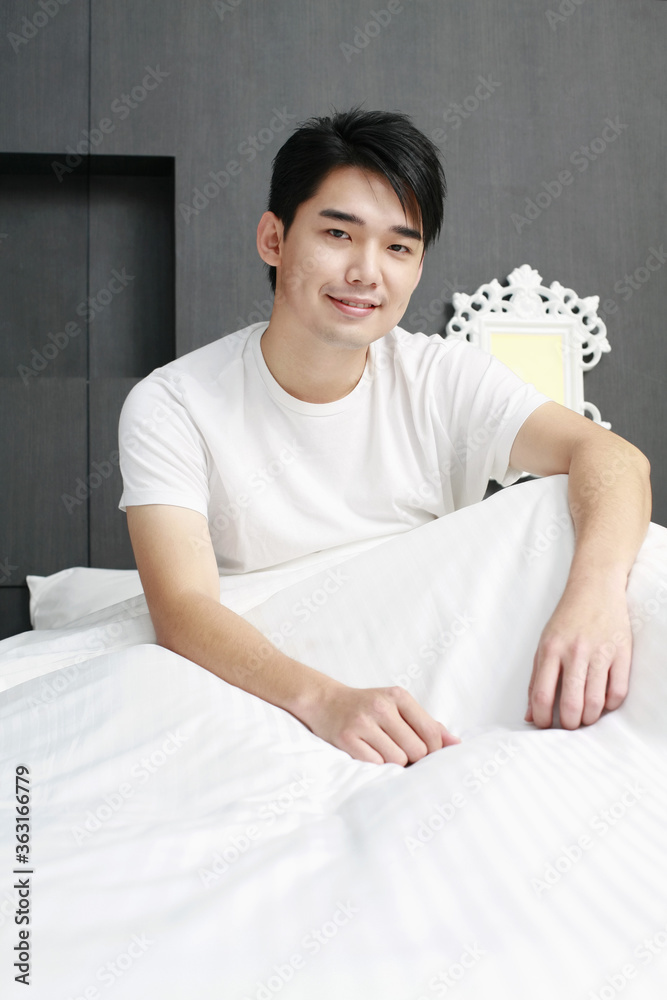 Man sitting on the bed smiling Man sitting on the bed smiling