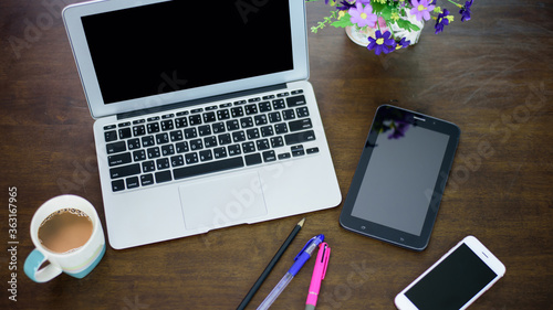 top view of office desk workspace with coffee cup, notebook, smartphone and keyboard on wood background with copy space,