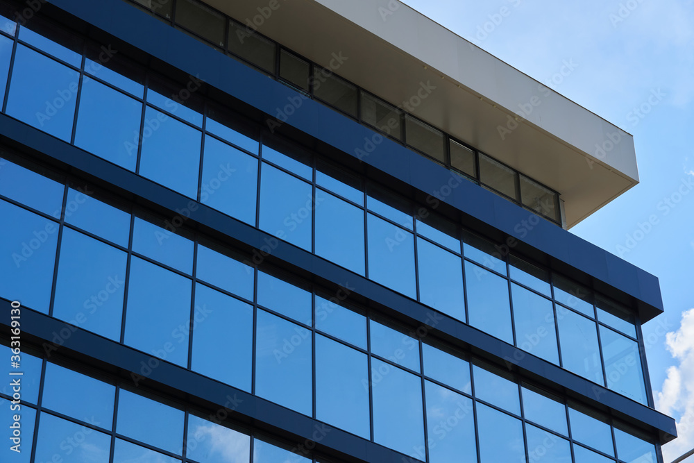 facade of a modern building on a bright Sunny day, blue sky and clouds reflecting in a glass, beautiful exterior of the new building facade of a modern building on a bright Sunny day, blue sky and clouds reflecting in a glass, beautiful exterior of the new building