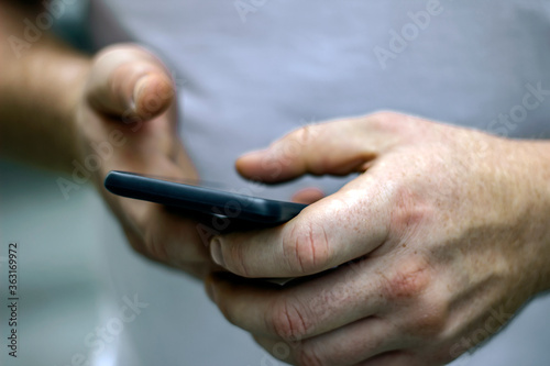 Unrecognized hands making call on mobile. Close up image of mans hands using modern technologies, checking smartphone while surfing net searching. Man texting on his mobile. Technology concept.