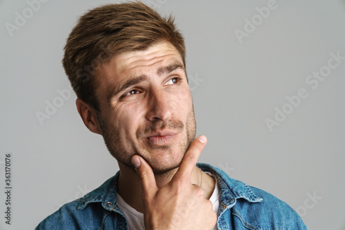 Portrait of redhead puzzled man posing and thinking at camera