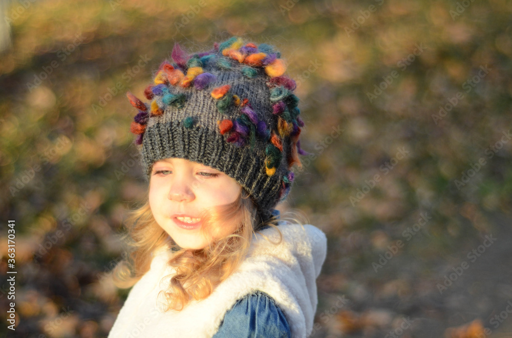 Picture of a blonde toddler girl in the funny knitted hat Picture of a blonde toddler girl in the funny knitted hat
