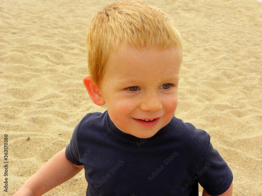 Portrait of a charming blond boy with gray eyes. A three year old boy looks into the distance and smiles. Happy baby Portrait of a charming blond boy with gray eyes. A three year old boy looks into the distance and smiles. Happy baby