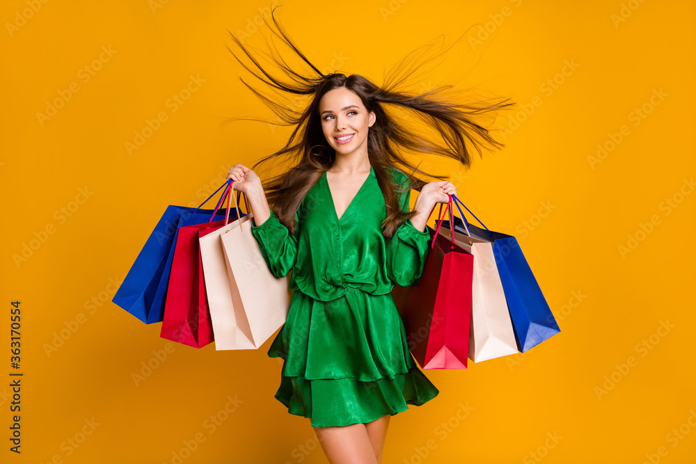 Portrait of her she nice attractive charming pretty cheerful cheery successful straight-haired girl holding in hands colorful bags isolated over bright vivid shine vibrant yellow color background