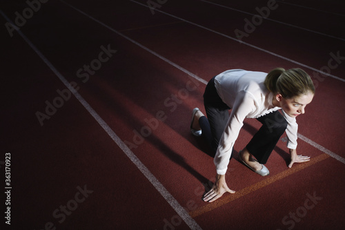 Businesswoman crouching on starting line