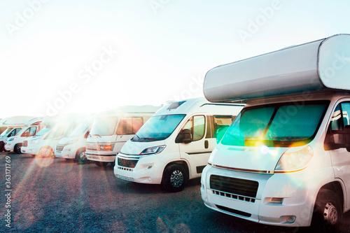 Caravans parked in a row in a camper parking area. Concept of summer tourism with RV, recreational vehicle.