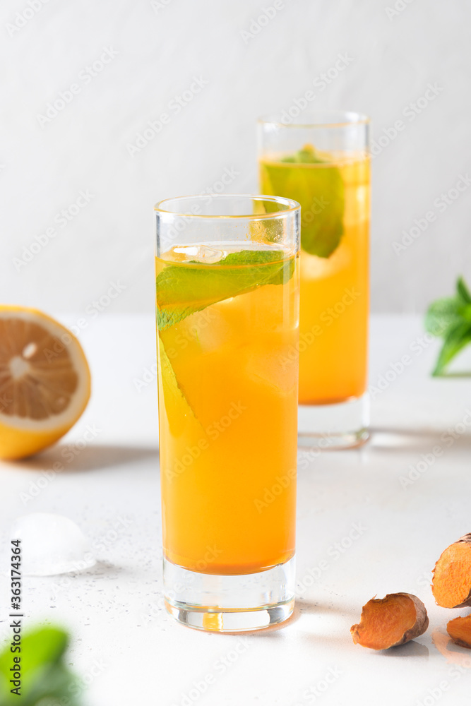 Fototapeta premium Jamu Indonesian herbal beverage with natural ingredients turmeric, ginger, lemon on white background. Close up.
