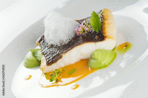 Photos Baked turbot fillet on a white plate