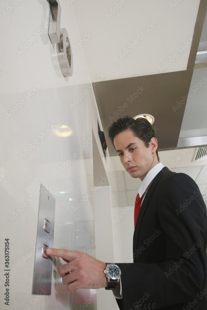 Businessman pushing elevator button Businessman pushing elevator button