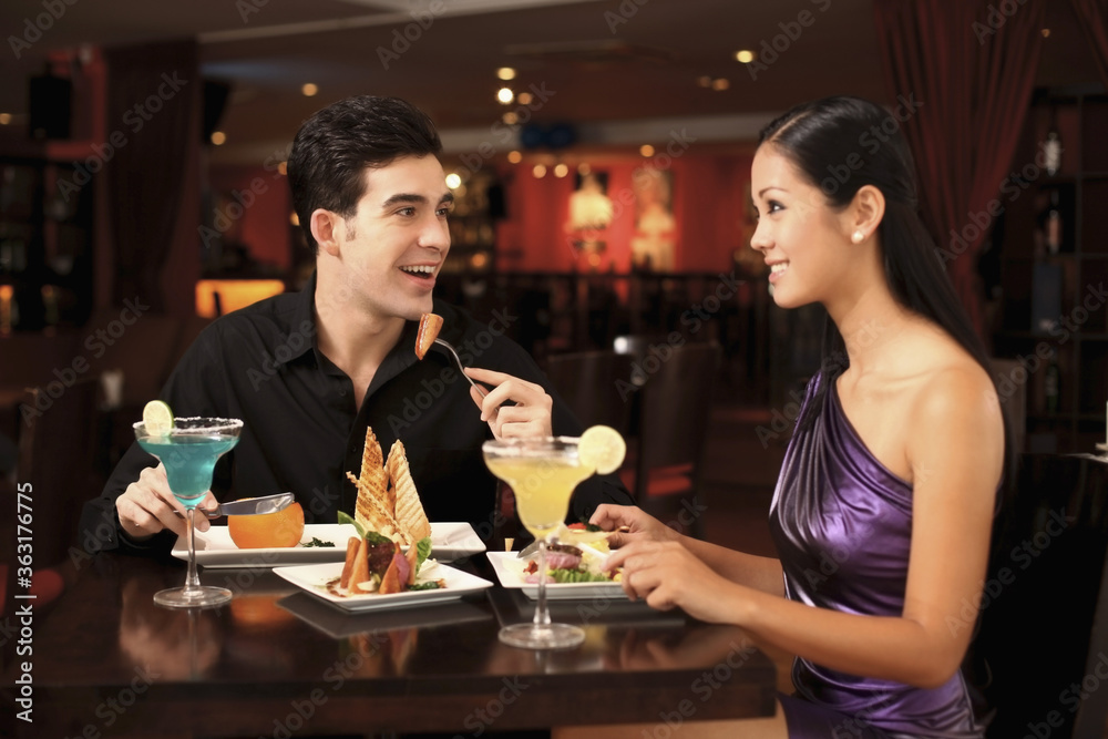 Man and woman chatting while having dinner together Man and woman chatting while having dinner together