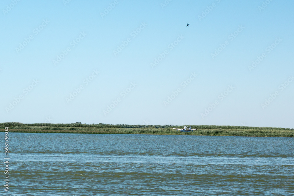 Small hydroplane landing on a lake in Danube Delta area, Dobrogea county, Romania, sunny summer day