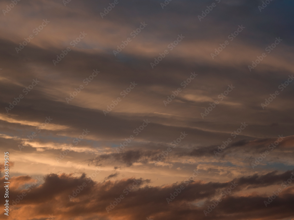 Light evening сumulus clouds in the sky. Colorful cloudy sky at sunset. Sky texture, abstract nature background