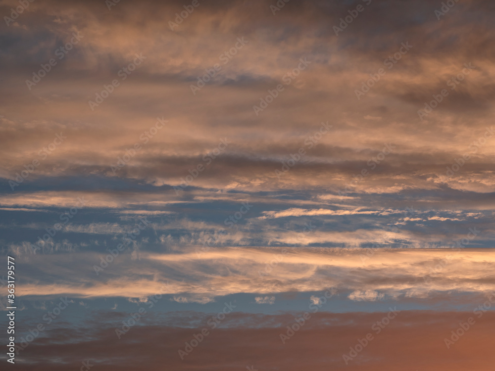 Light evening сumulus clouds in the sky. Colorful cloudy sky at sunset. Sky texture, abstract nature background