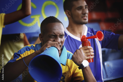 Men cheering in stadium © ImageHit