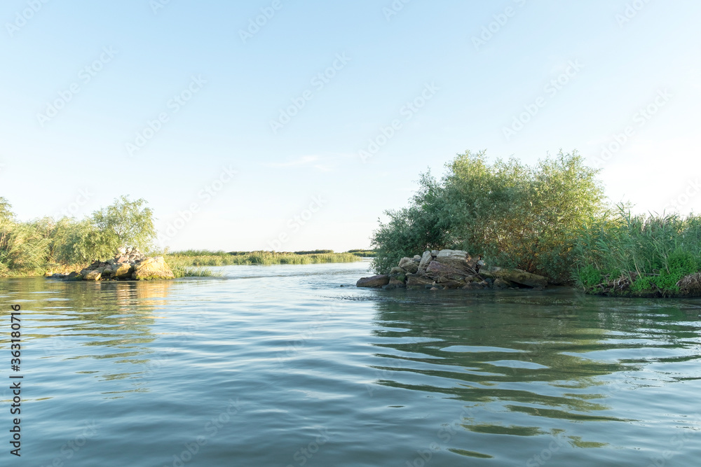 Channel landscape with waves in Danube Delta, Romania, on summer day Channel landscape with waves in Danube Delta, Romania, on summer day