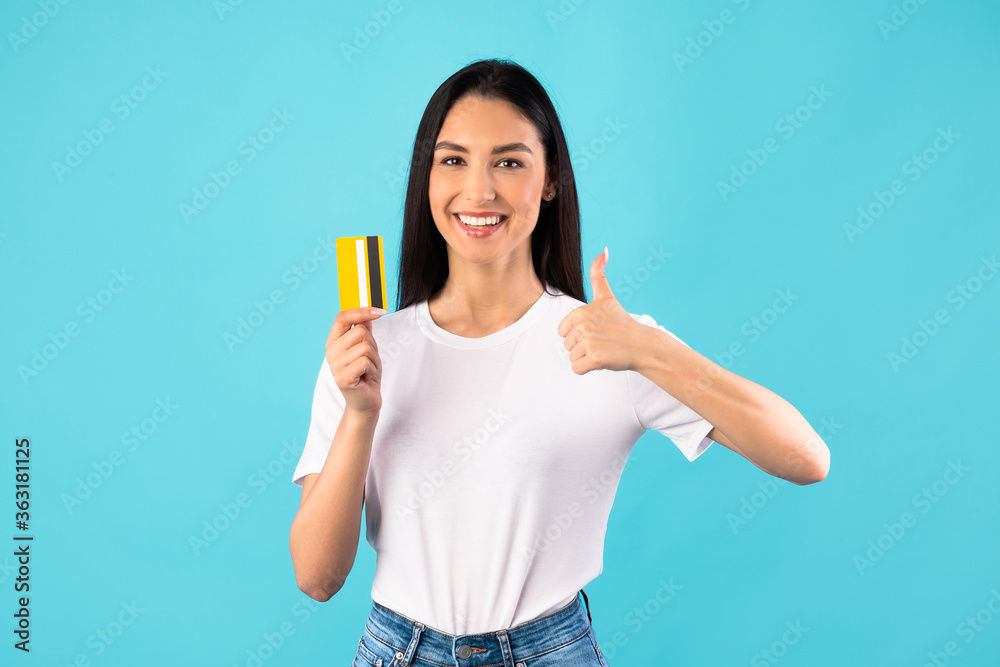 Girl holding credit card and showing thumb up Girl holding credit card and showing thumb up