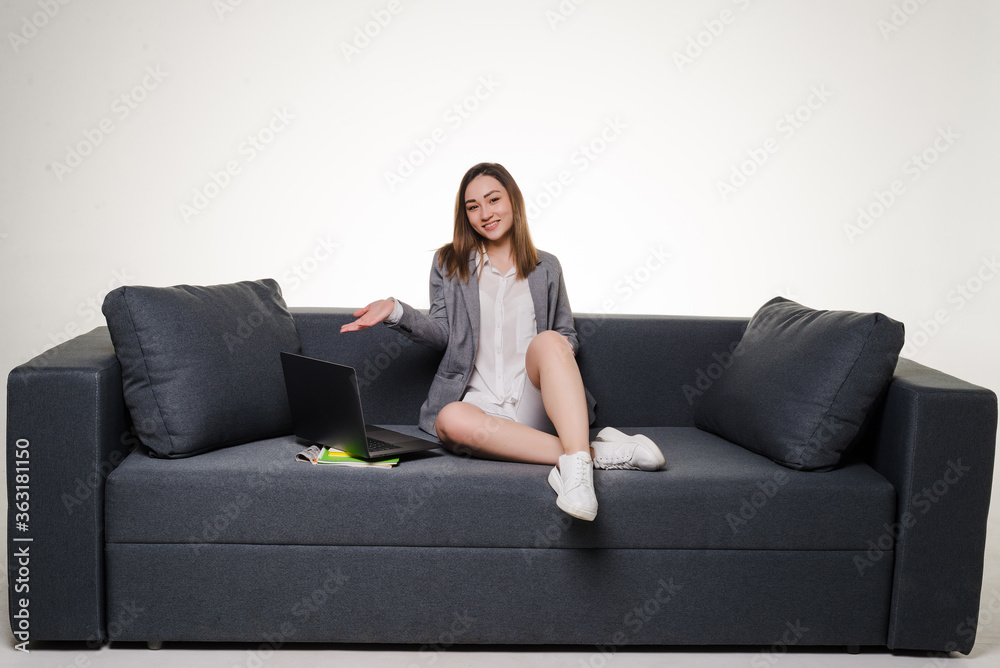Young woman lying on sofa at home working on laptop computer isolated on white background. Young woman lying on sofa at home working on laptop computer isolated on white background.