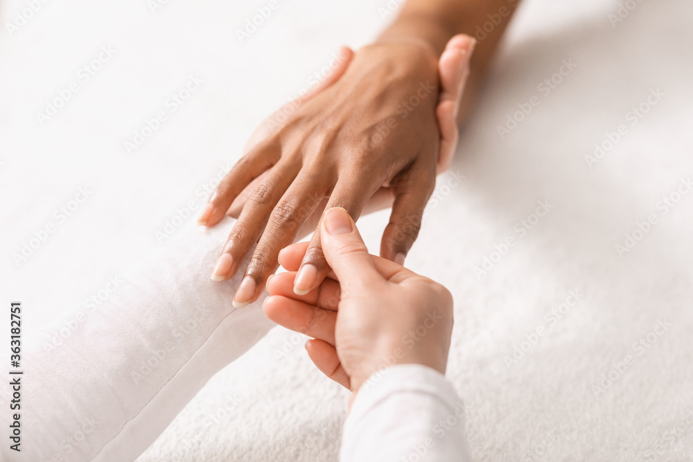 Top view of therapist rubbing black woman fingers Top view of therapist rubbing black woman fingers