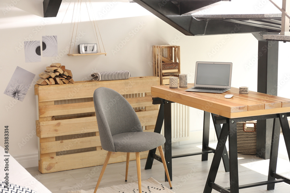 Fototapeta premium Elegant interior of room with workplace under stairs