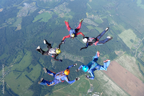 Skydiving. Skydivers are training and flying in the sky.