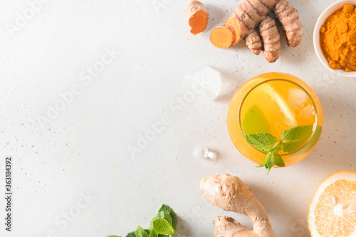 Jamu herbal beverage with turmeric, ginger on white background. View from above. Copy space. photo