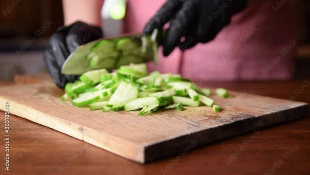 Female chef cutting raw vegetables and salad greens on a cutting Board Female chef cutting raw vegetables and salad greens on a cutting Board