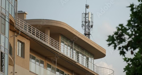 Telecommunication tower near building. Telecom tower antennas and satellite transmits the signals of cellular 5g 4g mobile signals to the consumers and smartphones. 4k. 60fps fps