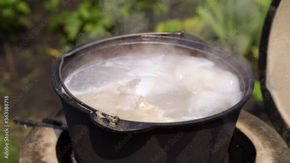 Soot covered bowler with steaming fish soup Soot covered bowler with steaming fish soup