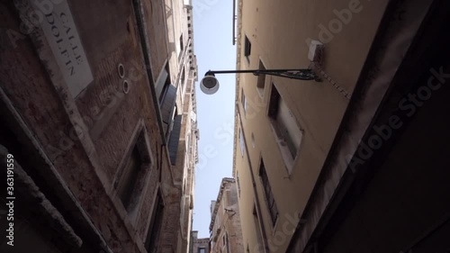 Wallpaper Mural Walking through of a narrow street in Venice surrounded by old typical buildings, Italy.  Torontodigital.ca