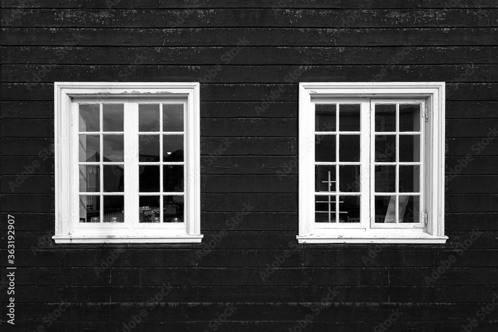 Two white windows on black facade