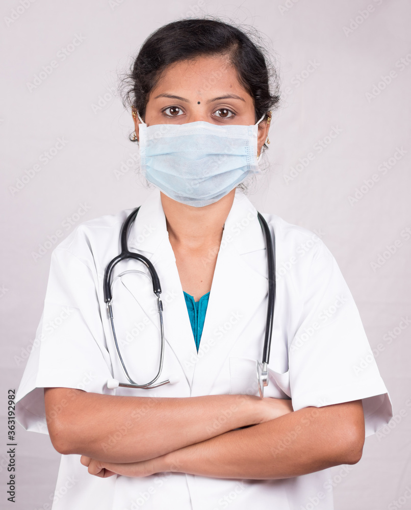 Portrait of Confident woman or female doctor wearing medical face mask standing with crossed arms on isolated background. Portrait of Confident woman or female doctor wearing medical face mask standing with crossed arms on isolated background.