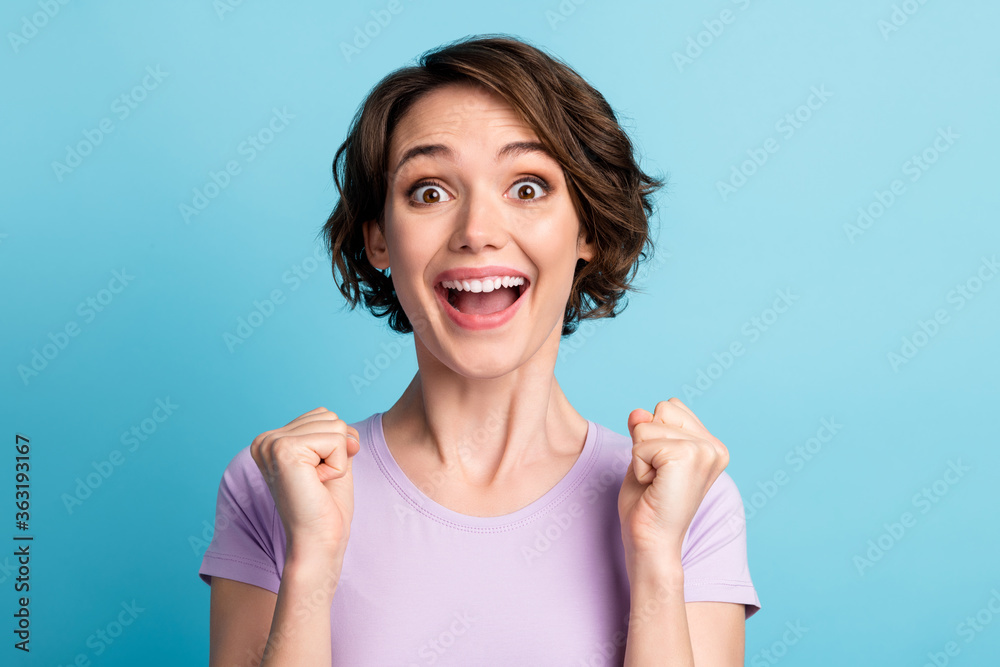 Portrait of astonished delighted girl impressed incredible lottery lucky win raise fists scream wow omg wear lilac outfit isolated over blue color background Portrait of astonished delighted girl impressed incredible lottery lucky win raise fists scream wow omg wear lilac outfit isolated over blue color background